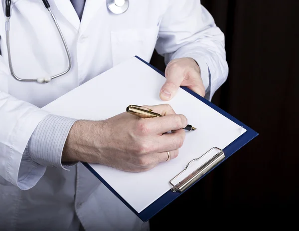 Közeli kezében egy orvos, az orvos aláírja a leíró dokumentumok. Az orvos azt írja kórtörténetét. írjon egy vényköteles betegadatokat története — Stock Fotó