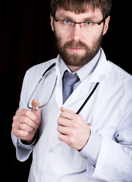Doktor v bílém rouchu lékařské, stojí a drží stetoskop — Stock fotografie
