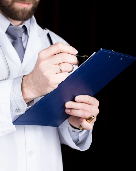 Mãos de perto de um médico, ele toma notas em um histórico médico pacientes — Fotografia de Stock