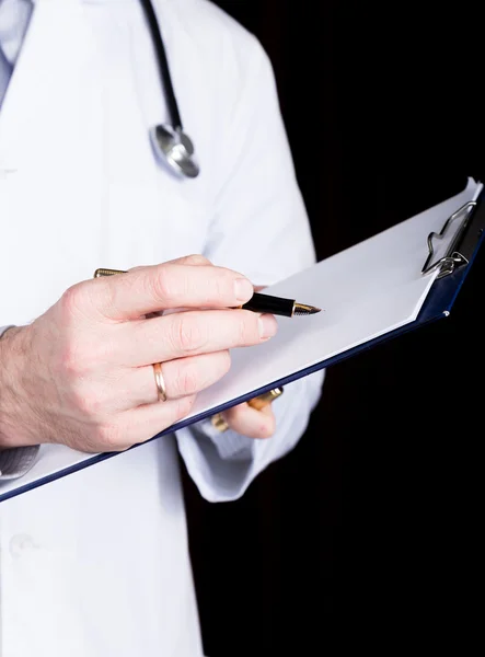 Yakın çekim yakışıklı bir doktor, o hastalar tıbbi geçmişinde notlar alır — Stok fotoğraf