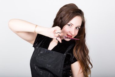 Very attractive and stylish professional hairdresser woman with scissors. hairdresser woman expresses different emotions and cuts himself bang