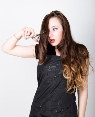 Very attractive and stylish professional hairdresser woman with scissors. hairdresser woman expresses different emotions and cuts himself bang