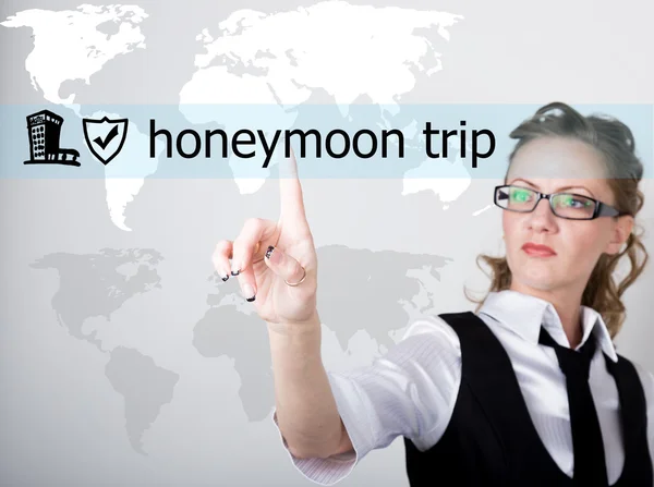 Viaje de luna de miel escrito en una pantalla virtual. Tecnologías de Internet en negocios y turismo. mujer en traje de negocios y corbata, presiona un dedo en una pantalla virtual — Foto de Stock