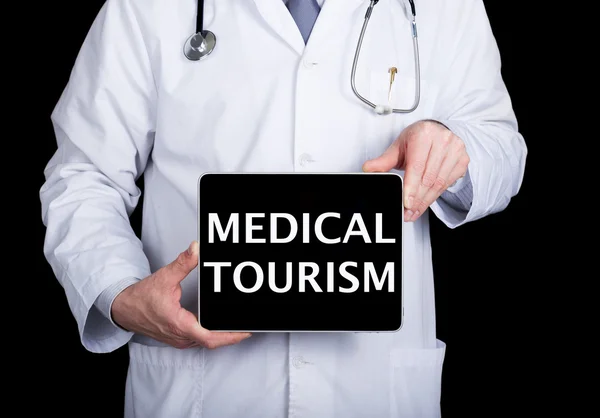 科技、互联网和网络医学概念 - 医生拿着一个带有医疗旅游标志的平板电脑。医药和旅游业的互联网技术 — 图库照片