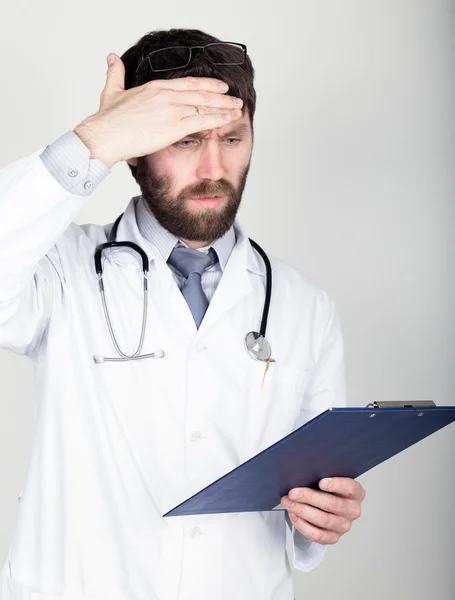 Bir Doktor'un yakın çekim portret notu için bir harita-case tutan, boynunda stetoskop. Alnını siliyor. farklı duygular — Stok fotoğraf