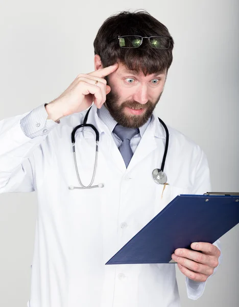 Bir Doktor'un yakın çekim portret notu için bir harita-case tutan, boynunda stetoskop. Tapınağında işaret parmağını büküyor. farklı duygular — Stok fotoğraf