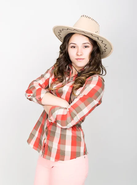 Beautiful curly girl in pink pants, a plaid shirt and cowboy hat. — Φωτογραφία Αρχείου