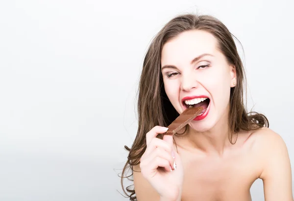 Κοντινό-up portret της όμορφης σέξι γυναίκα με κόκκινα χείλη τρώγοντας σοκολάτα — Φωτογραφία Αρχείου