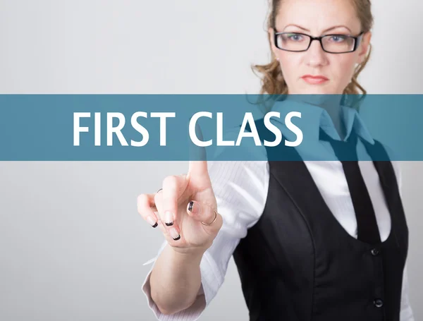 first class written on a virtual screen. Internet technologies in business and tourism. woman in business suit and tie, presses a finger on a virtual screen