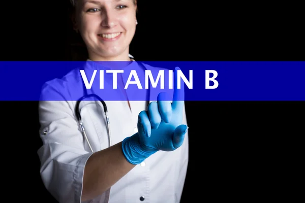 Internet-och teknikkoncept. leende kvinnlig läkare pressar ett finger på en virtuell skärm. vitamin b skrivet på en virtuell panel. Internet teknik inom medicinen — Stockfoto