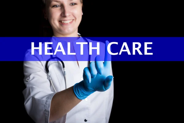 Internet und Technologie-Konzept. Lächelnde Ärztin drückt einen Finger auf einen virtuellen Bildschirm. Gesundheitswesen auf einem virtuellen Panel geschrieben. Internet-Technologien in der Medizin — Stockfoto