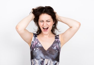 renkli bir elbise poz güzel genç esmer kadın ve farklı duygular ifade eder. kadın elleri çeşitli işaretler gösterir, saçlarını yırtarak. yakın çekim portret