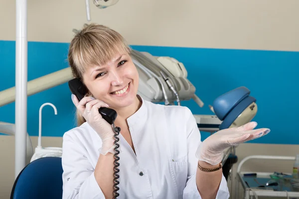 Administrador en la clínica dental que sostiene el teléfono, registros de pacientes en recepción — Foto de Stock