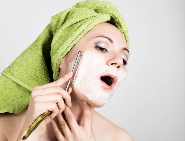 Beautiful Young woman dressed in a bath towel shaves with a straight razor. beauty industry and home skin care concept, extreme Beauty — Stock Photo, Image