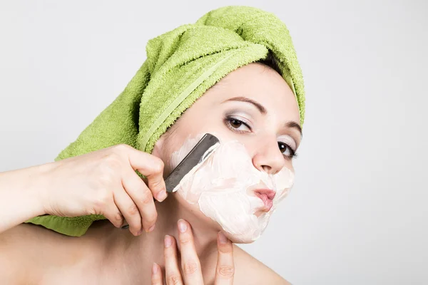 Beautiful Young woman dressed in a bath towel shaves with a straight razor. beauty industry and home skin care concept, extreme Beauty — Stock Photo, Image