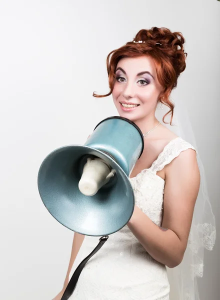 Hermosa novia en vestido de novia con maquillaje y peinado, ella grita en un megáfono. Relaciones públicas — Foto de Stock