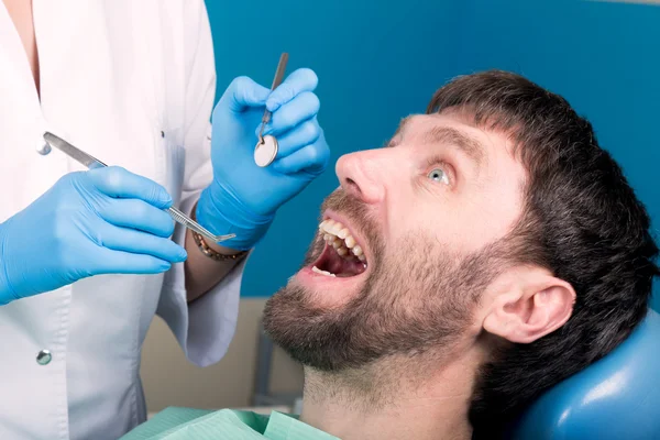 El médico examina la cavidad oral en la caries dental. Protección contra caries. Tratamiento de caries dental. Dentista trabajando con lámpara de polimerización dental en cavidad oral — Foto de Stock