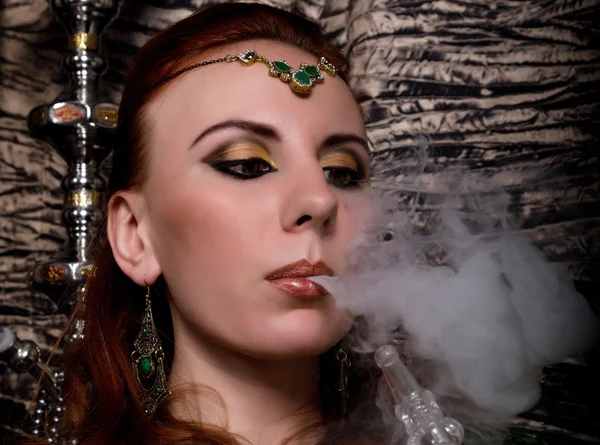 Szczegół portret eleganckie rude młode kobiety, makijaż, orientalne i szal nad jej głową jasne czerwone usta, ona pali fajki — Zdjęcie stockowe