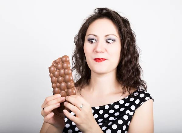 Güzel genç kadın bir çikolata yeme lekeli bir elbise giyer — Stok fotoğraf