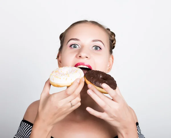 Дівчина в яскравому макіяжі їсть смачний пончик з глазур'ю. Весела радісна жінка з цукерками, десерт. концепція дієти. солодка їжа — стокове фото