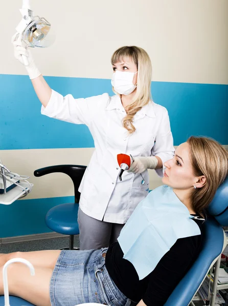 受付は、女性の歯科医。虫歯で口腔内を診察します。う蝕保護。医者は患者の麻酔注射を置きます. — ストック写真