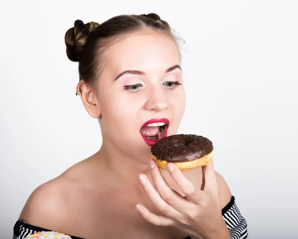 Dziewczyna w jasny makijaż jedzenie smaczne pączek z lukrem. Zabawny, radosny kobieta z słodycze, deser. pojęcie diety. fast foodów — Zdjęcie stockowe