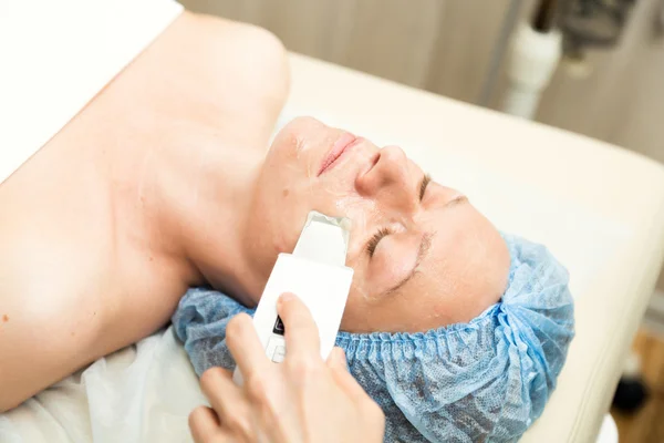 Young woman lying down in a spa salon and having a Ultrasonic face cleaning. The cosmetic procedures for the face. Beauty treatments in the spa salon. Facial Skin Care — Stock Photo, Image