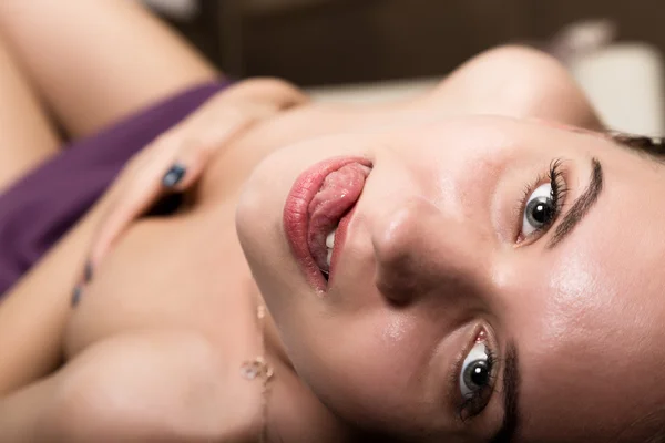 Sexy glamour pose meisje liggend op de vloer en flirts. tonen van tong, lippen likken — Stockfoto