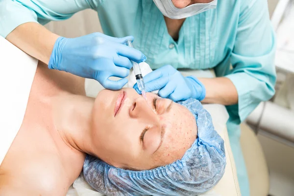 Beautician hace biorevitalización a la mujer joven. Los procedimientos cosméticos para la cara. Tratamientos de belleza en el salón de spa. Cuidado facial de la piel — Foto de Stock