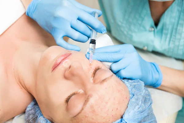 Beautician hace biorevitalización a la mujer joven. Los procedimientos cosméticos para la cara. Tratamientos de belleza en el salón de spa. Cuidado facial de la piel —  Fotos de Stock