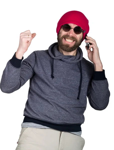 Mode hipster onhartelijk mens in zonnebrillen en kleurrijke kleding. doet een beroep op een telefoon en lachend. Hij hief zijn hand omhoog. geïsoleerd op witte achtergrond — Stockfoto