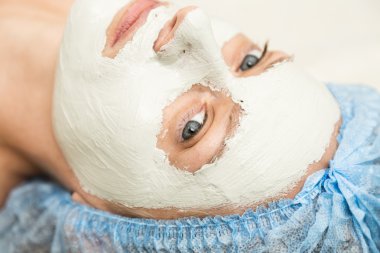 Bir spa salonda yalancılık aşağı ve yüz güzelliği tedavi olan genç kadın. Yüz için kozmetik prosedürler. Cilt Bakımı