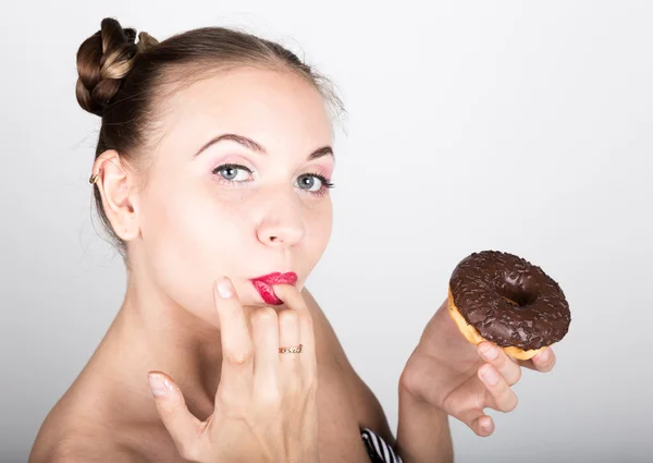 Девушка в ярком макияже ест вкусный пончик с глазурью. Забавная радостная женщина сладости, десерт. Концепция диеты. фастфуд. Липкая пальцы — стоковое фото