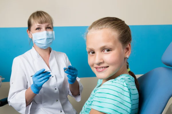 Niña feliz con la boca abierta sometida a tratamiento dental en la clínica. El dentista revisó y curó los dientes de un niño paciente en el consultorio dental — Foto de Stock