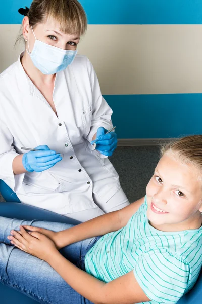 Glückliches kleines Mädchen mit offenem Mund, das sich einer Zahnbehandlung in der Klinik unterzieht. Zahnarzt überprüft und heilt Zähne eines Kinderpatienten in der Zahnarztpraxis — Stockfoto