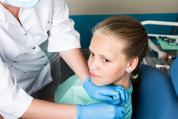 Niña feliz con la boca abierta sometida a tratamiento dental en la clínica. El dentista revisó y curó los dientes de un niño paciente en el consultorio dental — Foto de Stock