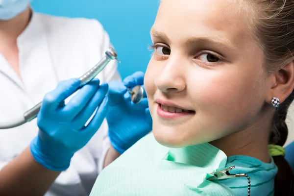 Niña feliz con la boca abierta sometida a tratamiento dental en la clínica. El dentista revisó y curó los dientes de un niño paciente en el consultorio dental — Foto de Stock