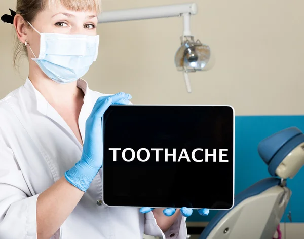 Technology, internet and networking in medicine concept - femail dentist holding a tablet pc with toothache sign. at the dental equipment background — Stock Photo, Image