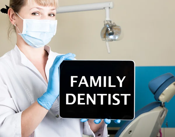 Tecnologia, internet e rede no conceito de medicina dentista femail segurando um tablet pc com sinal de dentista familiar. no fundo do equipamento dentário — Fotografia de Stock