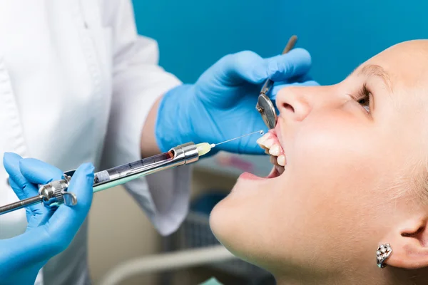 Lycklig liten flicka med öppen mun genomgå tandvård på kliniken. Tandläkaren kollade och bota tänder en barn patient i tandläkarens — Stockfoto