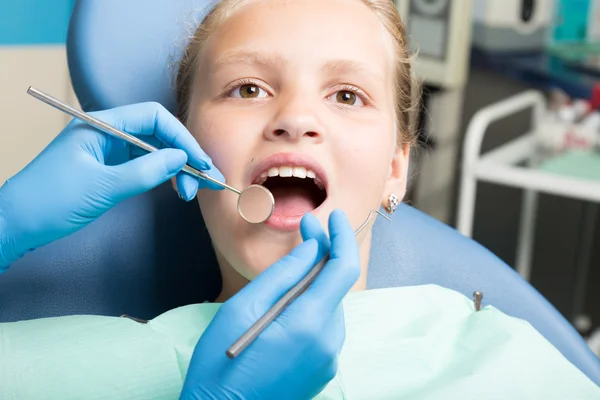 Niña feliz con la boca abierta sometida a tratamiento dental en la clínica. El dentista revisó y curó los dientes de un niño paciente en el consultorio dental — Foto de Stock