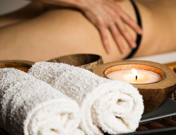 Mujer joven recibiendo un masaje de celulitis en el salón de spa. primer plano vela y toallas — Foto de Stock