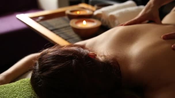 年轻女子在 spa 沙龙接受按摩一下后背。男按摩师的特写手 — 图库视频影像