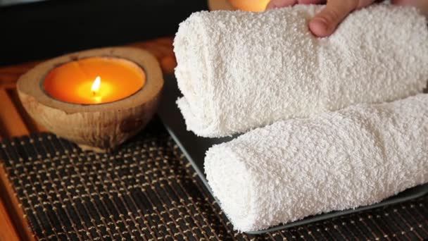 Massage dans le salon de spa. bougie brûle, masseur met les serviettes — Video