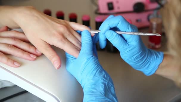 Cosmetician gör manikyr och sågar naglar av klienten. Manikyr nagelvård i en skönhetssalong — Stockvideo