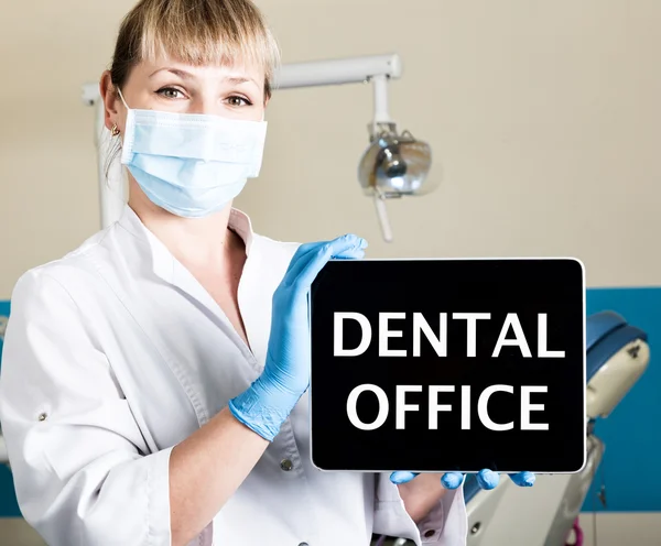 Tecnología, Internet y la creación de redes en el concepto de medicina dentista femail celebración de una tableta de PC con signo de consultorio dental. en el fondo del equipo dental — Foto de Stock