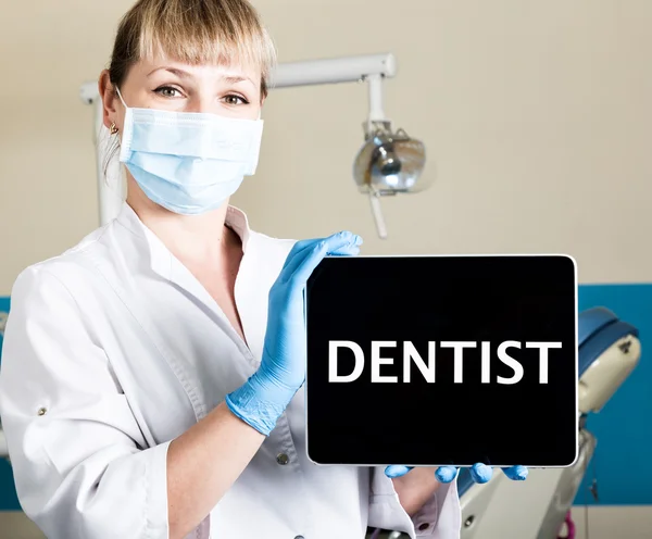 Технологія, Інтернет та мережа в концепції медицини - стоматолог, що тримає планшетний ПК зі знаком стоматолога. на фоні стоматологічного обладнання — стокове фото