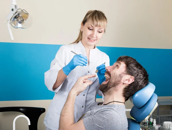 El médico examina la cavidad oral en la caries dental. Protección contra caries. Tratamiento de caries dental. Dentista trabajando con lámpara de polimerización dental en cavidad oral — Foto de Stock