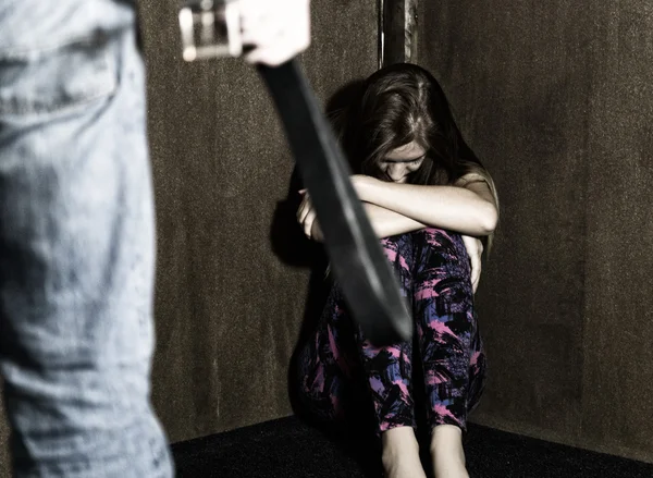 Frightened woman sitting in the corner with a faceless man holding a belt, a conceptual shoot portraying the process and effects of domestic violence — Stock Photo, Image