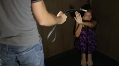 korkmuş kadın bir kemer, kavramsal bir çekim süreci ve aile içi şiddet etkileri tasvir tutarak meçhul bir adamla köşede oturmuş